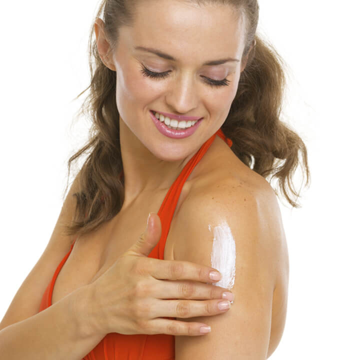 Woman applying sunscreen to upper arm